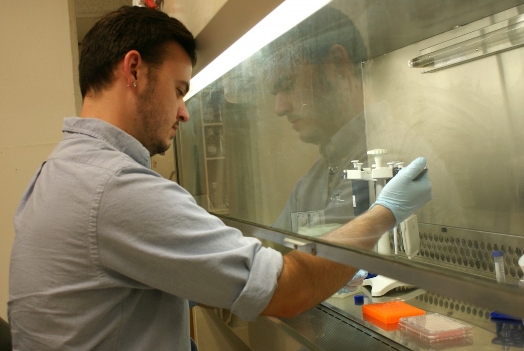Dylan Burroughs, second-year veterinary student at Ohio State, works in the lab with a feline cell line. July 21, 2015; Columbus, Ohio. 